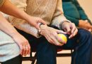 ein Mensch berührt die Hand einer älteren Person