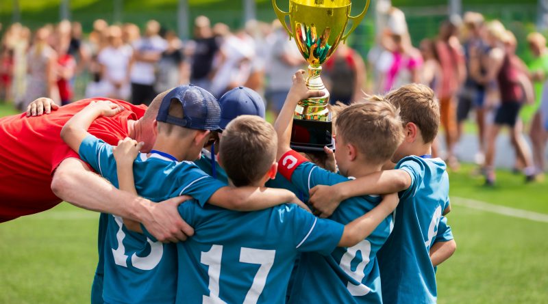 Kinder mit einem Pokal im Sportverein