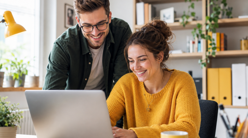 Zwei junge Erwachsene sitzen vor einem Laptop und nehmen an einem Webinar teil.