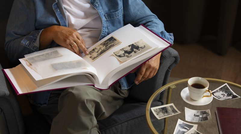 Älterer Mann schaut in ein Fotoalbum. Biographien bestimmen den Wunsch gemeinnützig zu vererben.